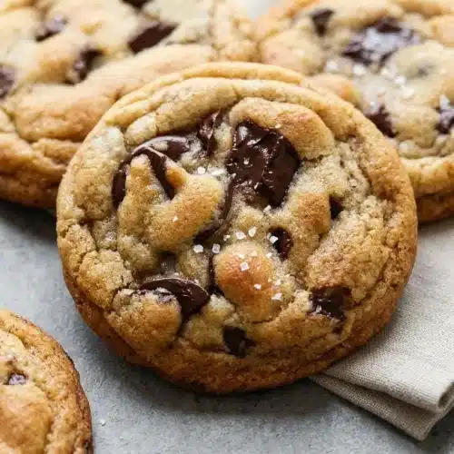 Brown butter chocolate chip cookies with golden rippled edges, molten chocolate puddles, and flaky sea salt.