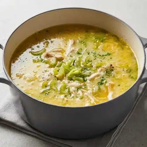 Steaming chicken and rice soup topped with tender shredded chicken, tender rice, and fresh parsley.