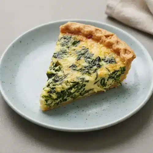 Freshly baked spinach quiche recipe with a golden flaky crust and silky cheese custard filling.