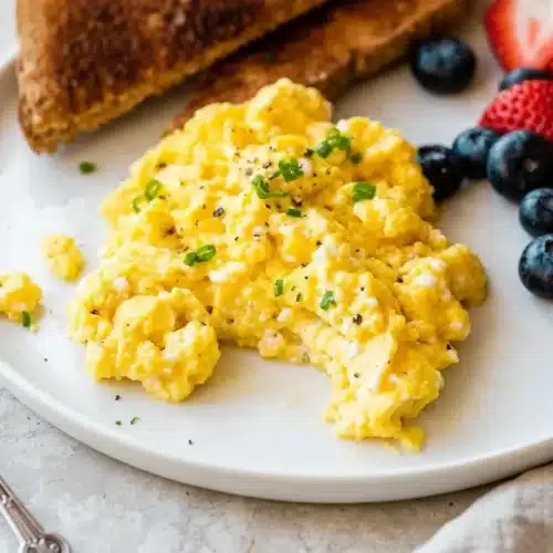 Fluffy cottage cheese scrambled eggs recipe cooked into tender, creamy curds with a soft glossy finish.