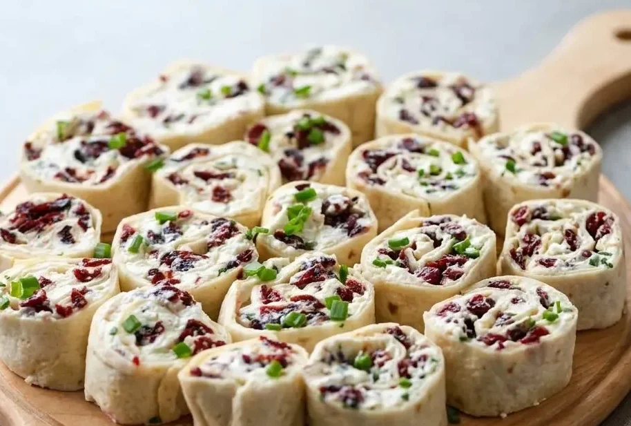 Cranberry feta pinwheels tightly rolled in tortillas showcasing creamy cheese and sweet ruby-red cranberries.