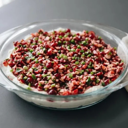 Cranberry jalapeno dip layered over whipped cream cheese with a glossy ruby red relish.