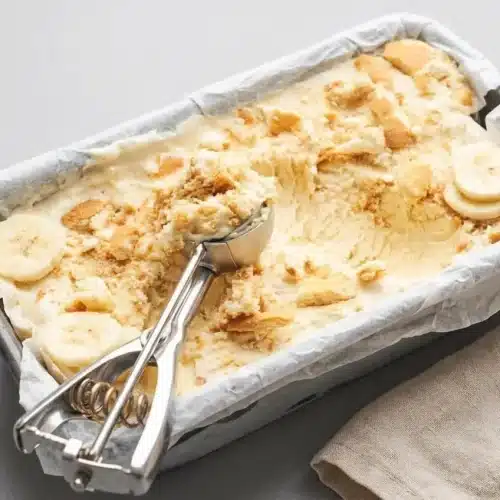 Scoops of creamy banana pudding ice cream loaded with crushed vanilla wafers and soft banana slices.