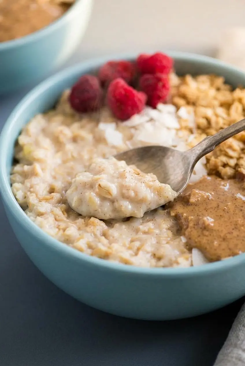 Spoon lifting a velvety scoop of egg white oatmeal showing its smooth custard-like texture.
