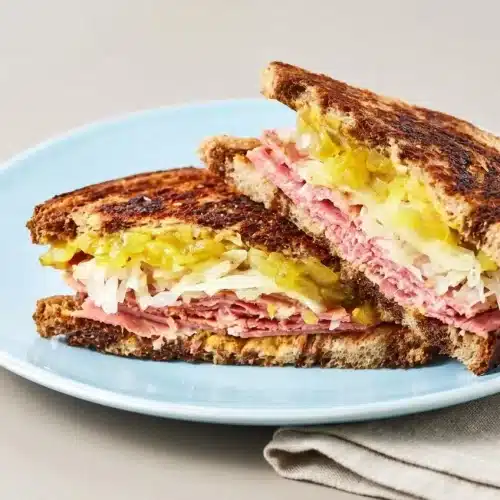 Corned beef sandwich on toasted seeded rye with savory meat, sauerkraut, and a crisp, buttery golden crust.