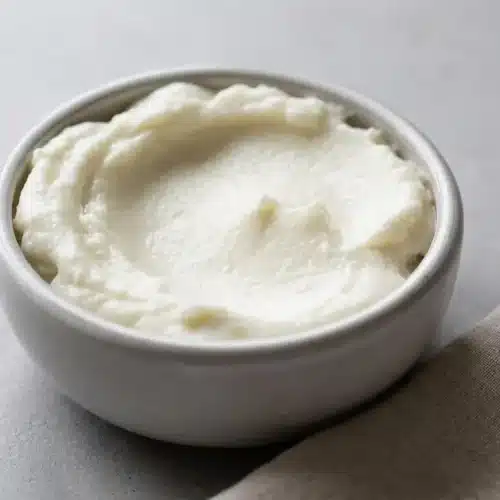 Fluffy, glossy garlic sauce whipped to stiff peaks in a shallow serving bowl.