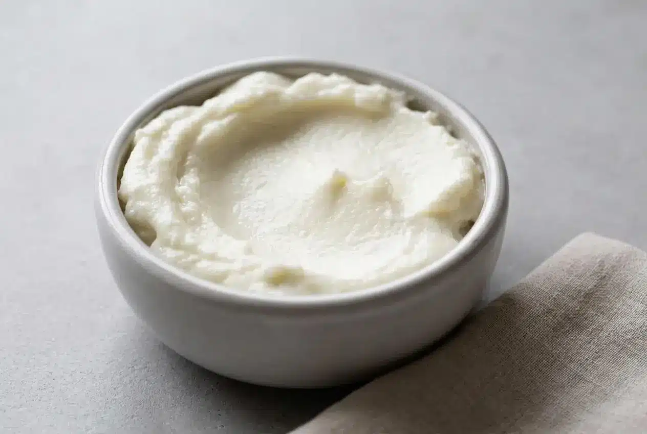 Fluffy, glossy garlic sauce whipped to stiff peaks in a shallow serving bowl.