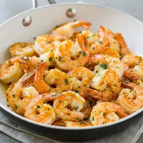 Skillet of tender garlic butter shrimp coated in a glossy lemon butter sauce and fresh parsley
