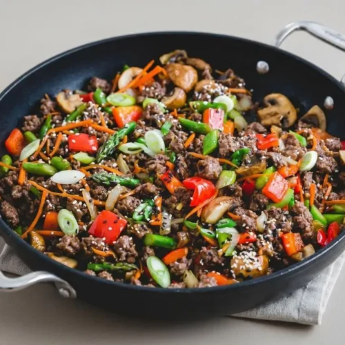 Ground beef stir fry with crisp-tender vegetables coated in a glossy garlic ginger sauce and sesame seeds.