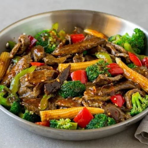 Tender slices of hunan beef stir-fried with crisp broccoli and red peppers in a glossy spicy savory sauce.