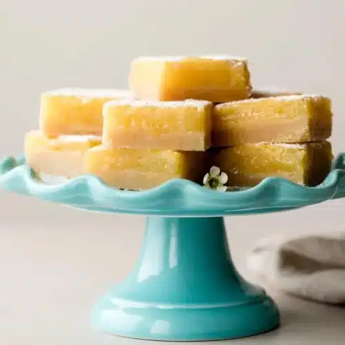 Lemon bars with shortbread crust dusted with confectioners sugar and showing silky citrus filling.