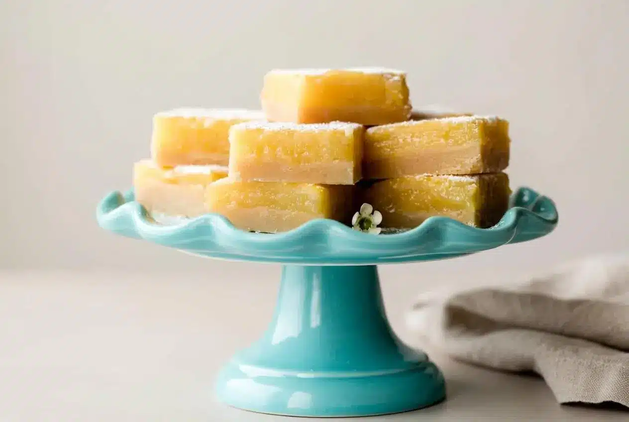 Lemon bars with shortbread crust dusted with confectioners sugar and showing silky citrus filling.