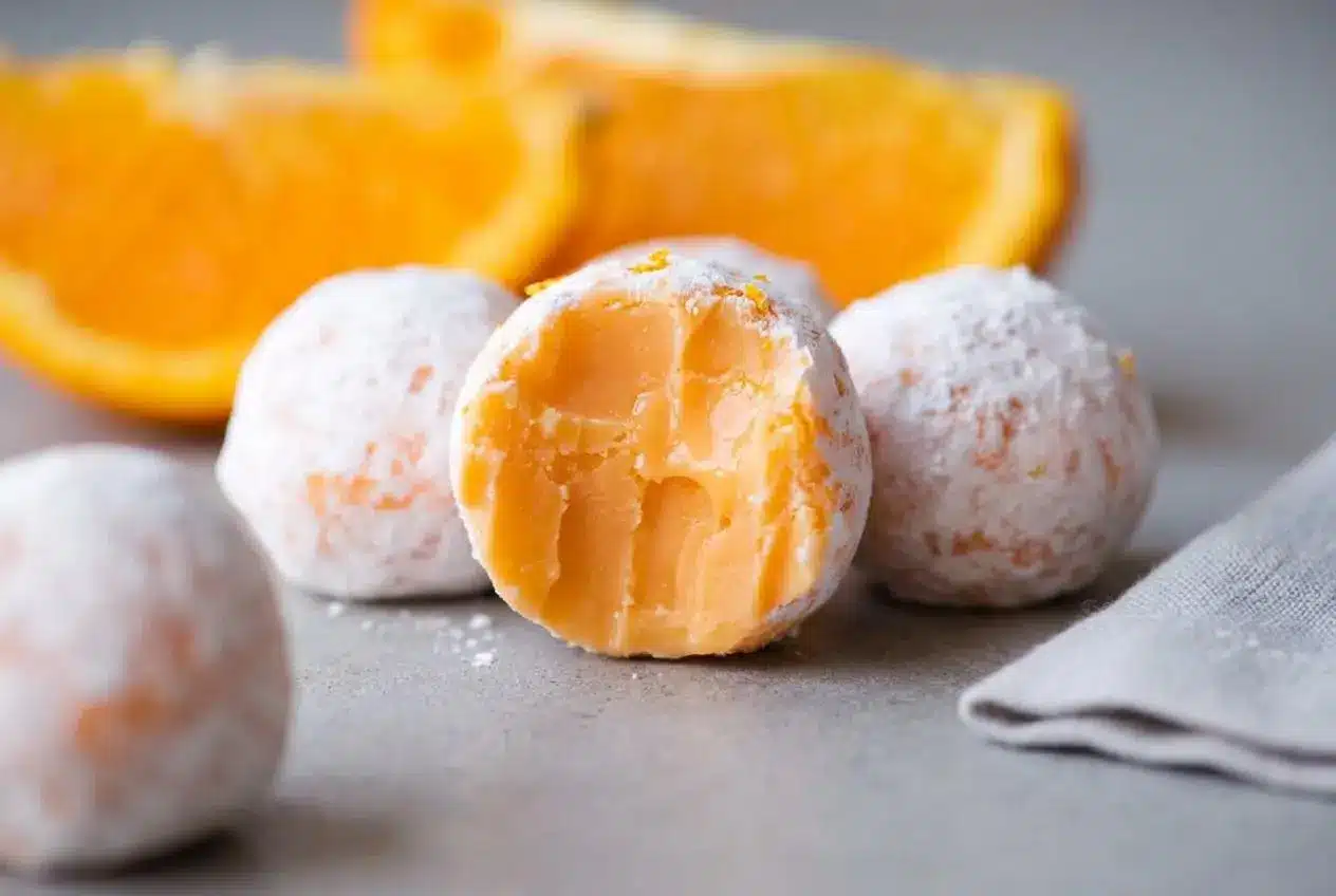 Orange creamsicle truffles dusted in fine powdered sugar with a velvety citrus ganache center.