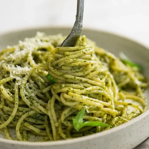 Pesto pasta recipe served in a ceramic bowl with a silky, vibrant green basil sauce and grated Parmesan.