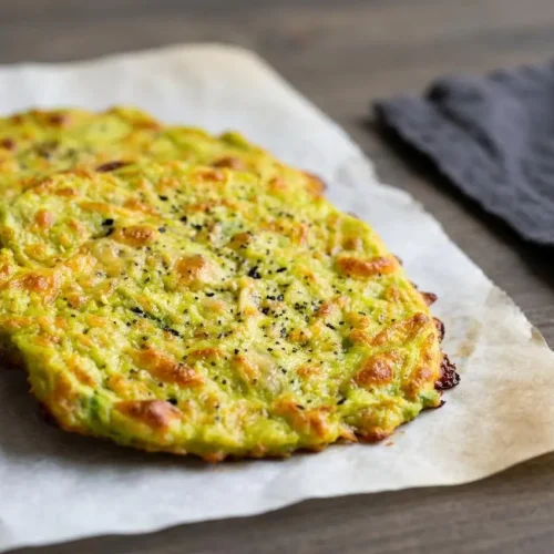 Baked 3 ingredient avocado bread rounds with golden crisp cheese edges and tender green-flecked centers.