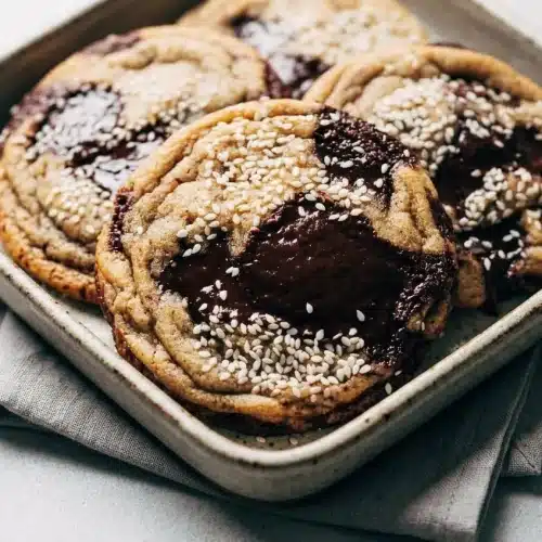 Brown Butter Miso Chocolate Chip Cookies with golden edges, melted dark chocolate pools, and toasted sesame tops.
