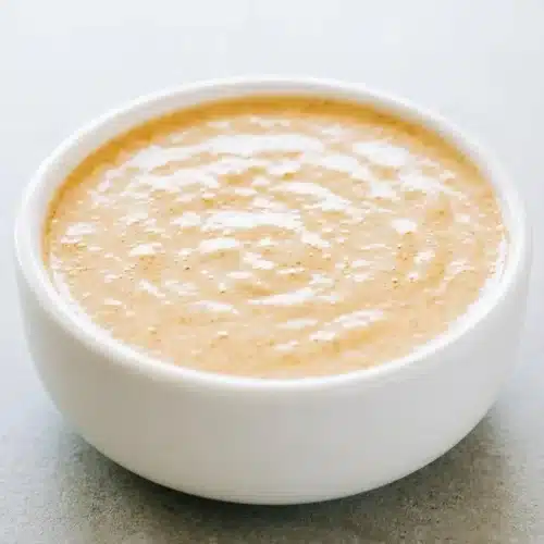 Creamy cottage cheese queso in a ceramic bowl with a warm, glossy finish and taco spices.