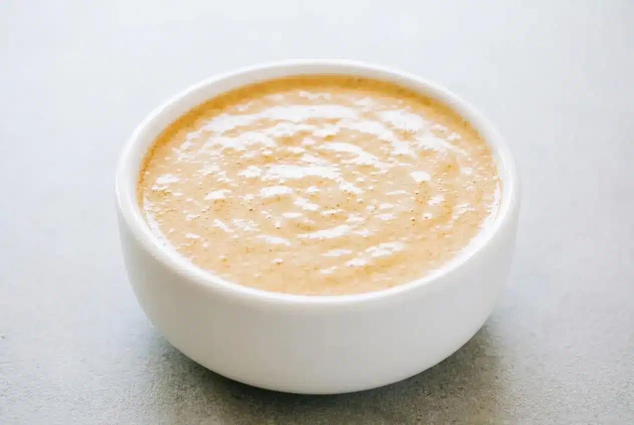 Creamy cottage cheese queso in a ceramic bowl with a warm, glossy finish and taco spices.