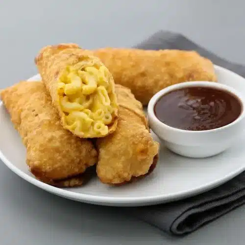 Golden-brown mac and cheese egg rolls with crisp blistered wrappers and creamy sharp cheddar macaroni filling