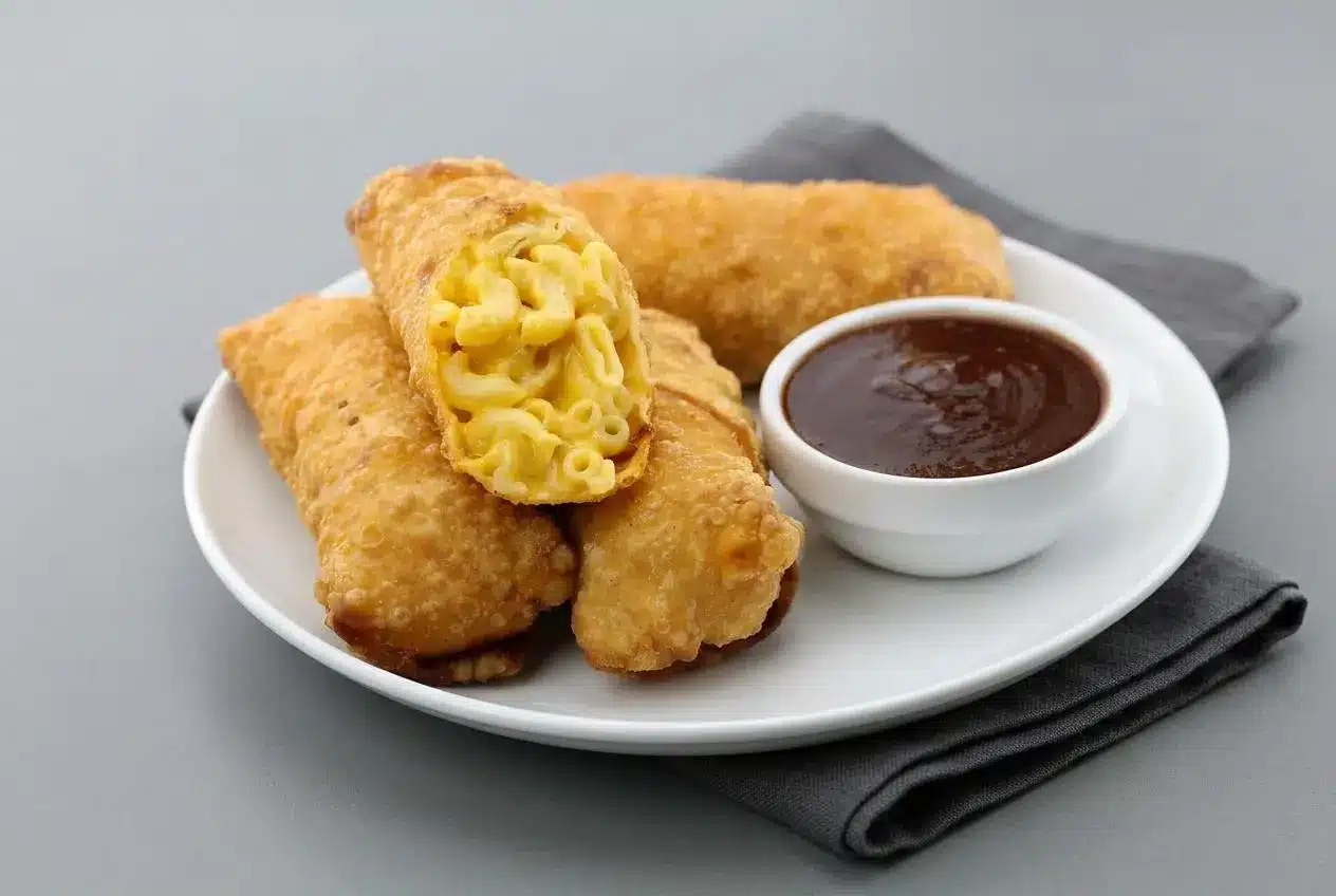 Golden-brown mac and cheese egg rolls with crisp blistered wrappers and creamy sharp cheddar macaroni filling