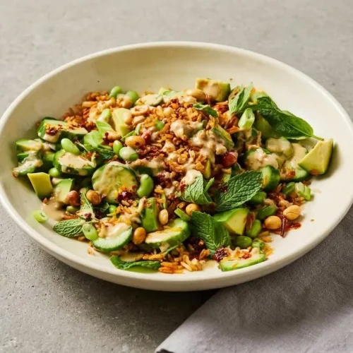 Crispy rice salad layered with golden toasted grains, fresh sliced cucumbers, edamame, and creamy avocado.