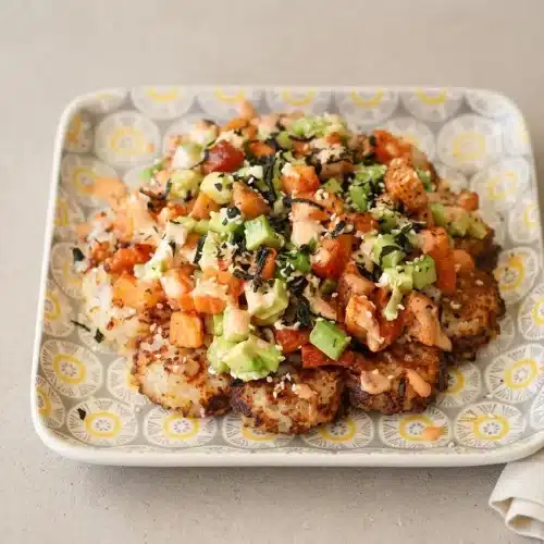 Crispy golden sushi waffles topped with flaked baked salmon, cucumber, avocado, and spicy mayo.