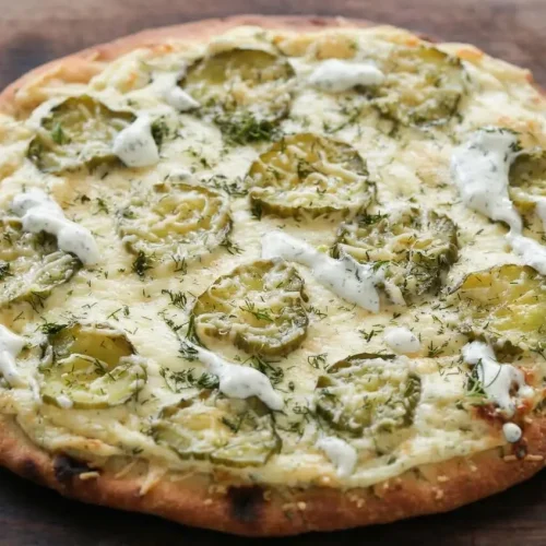 Freshly baked dill pickle pizza with melty mozzarella, thin kosher dill pickles, and golden Parmesan on a crisp crust.