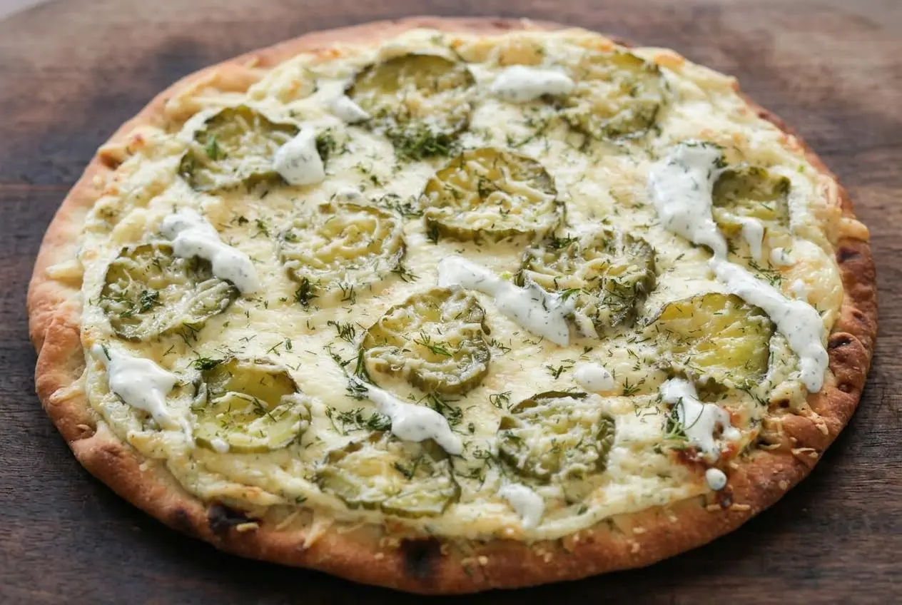 Freshly baked dill pickle pizza with melty mozzarella, thin kosher dill pickles, and golden Parmesan on a crisp crust.