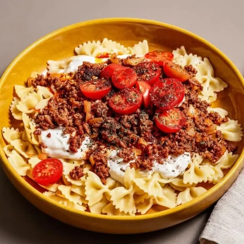 Turkish pasta layered with spiced ground beef, smooth garlic yogurt, and sizzling chili butter on farfalle.