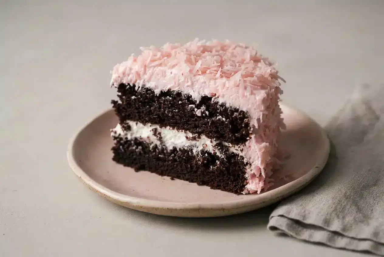 Hostess snowball cake recipe with moist chocolate layers, billowy marshmallow frosting, and chewy pink coconut coating