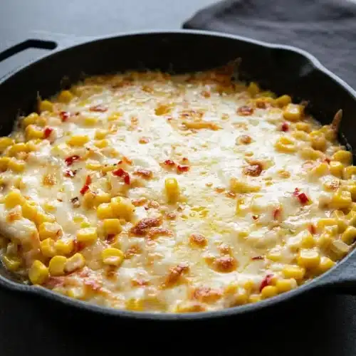 Skillet of korean corn cheese recipe with bubbly golden mozzarella over sweet yellow corn and creamy mayo