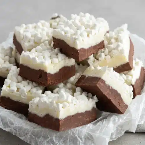 Sliced squares of hot chocolate fudge with a rich dark chocolate base, creamy white chocolate layer, and crunchy mallow bits