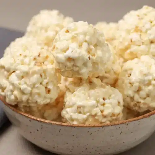 Golden marshmallow popcorn balls with a glossy browned butter coating and crisp salted popcorn clusters