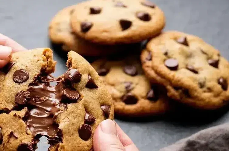 Warm nutella stuffed cookies broken open to show crisp golden edges, dark chocolate chips, and molten hazelnut filling.