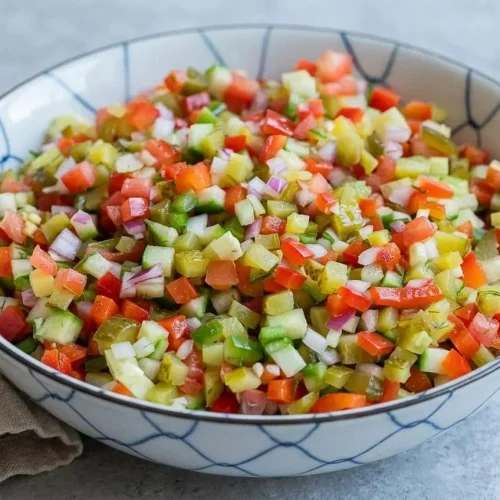 Bowl of chunky pickle de gallo recipe made with crisp diced dill pickles, tomatoes, cucumbers, red bell pepper, and fresh dill