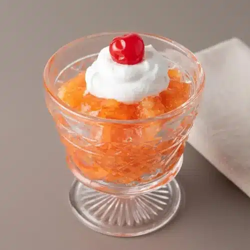 Pineapple Carrot Jello Salad with glossy orange gelatin and finely shredded carrots unmolded on a platter.