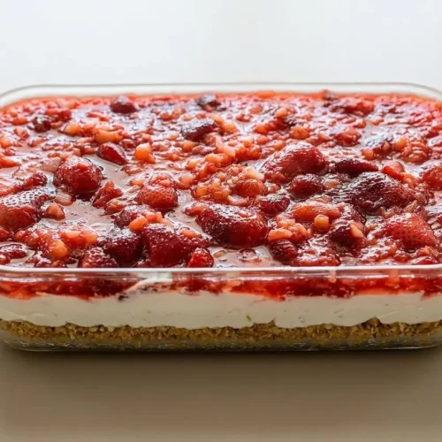 Pineapple pretzel salad square showing crunchy pretzel crust, fluffy cream cheese filling, and ruby fruit gelatin.