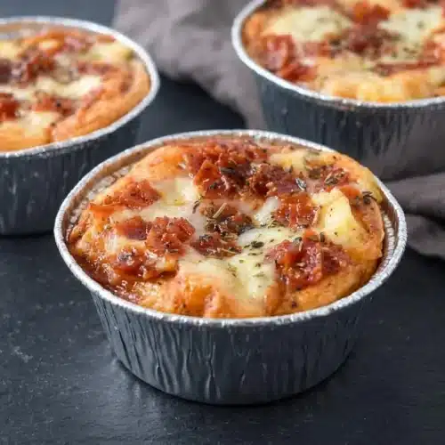 Baked pizza pot pies in biscuit cups with golden garlic crust, gooey melted mozzarella, and chopped pepperoni.